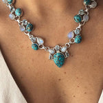 Colar em estilo boémio adornado com flores brancas e turquesa.