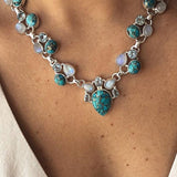 Colar em estilo boémio adornado com flores brancas e turquesa.