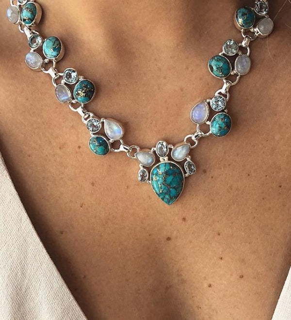 Colar em estilo boêmio adornado com flores brancas e turquesa.