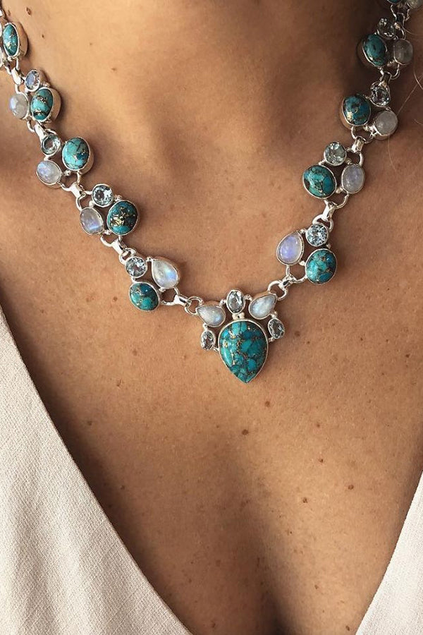 Colar em estilo boêmio adornado com flores brancas e turquesa.