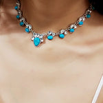 Colar em estilo boémio adornado com flores brancas e turquesa.