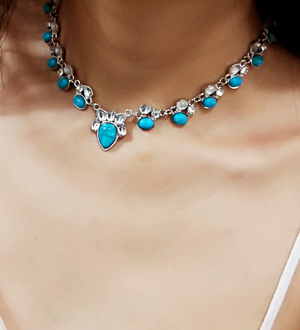 Colar em estilo boémio adornado com flores brancas e turquesa.