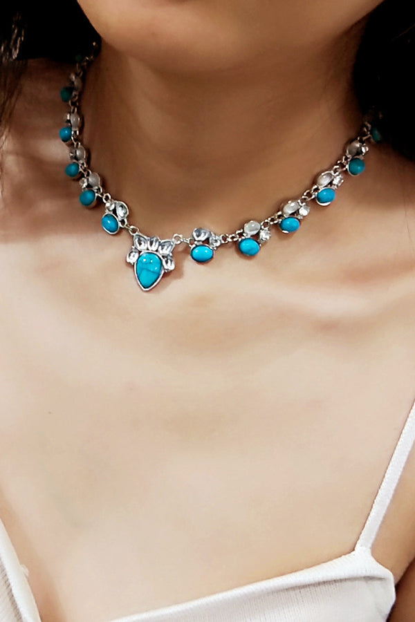 Colar em estilo boêmio adornado com flores brancas e turquesa.