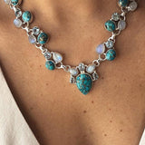 Colar em estilo boêmio adornado com flores brancas e turquesa.