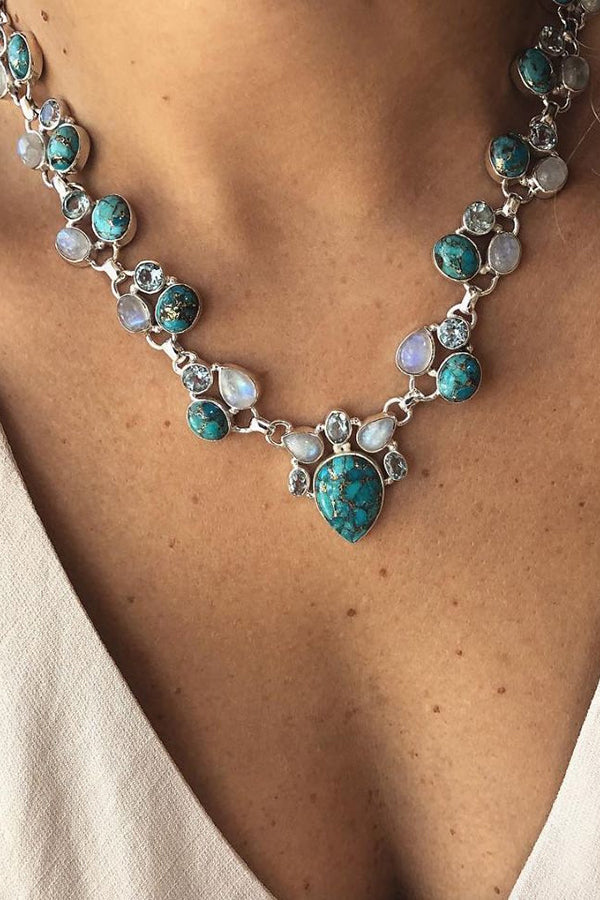 Colar em estilo boêmio adornado com flores brancas e turquesa.