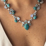 Colar em estilo boémio adornado com flores brancas e turquesa.