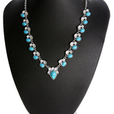 Colar em estilo boémio adornado com flores brancas e turquesa.